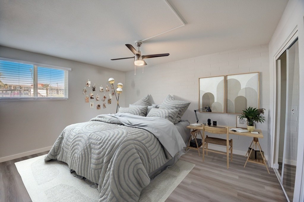 A bedroom with a large bed and a ceiling fan.