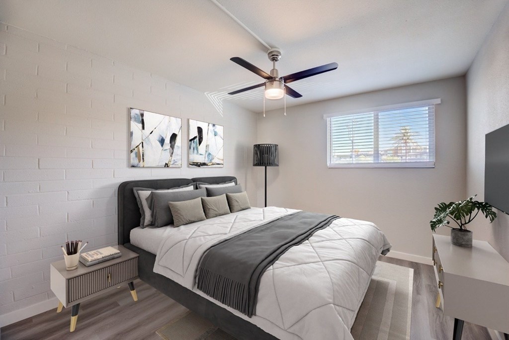 A bedroom with a large bed and a ceiling fan.