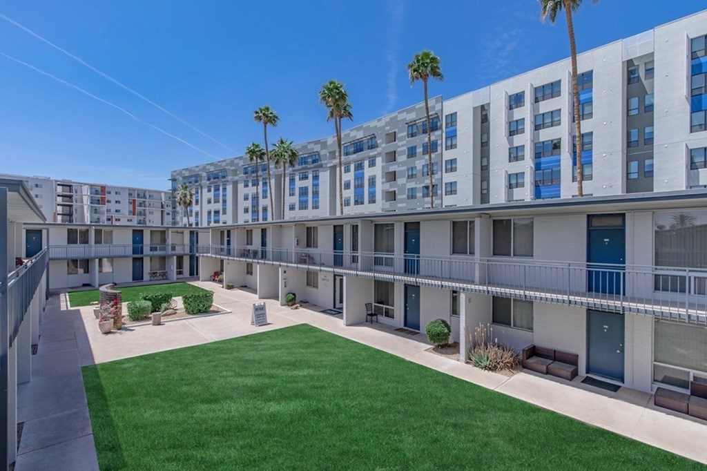 A sunny day at a modern apartment complex with palm trees.