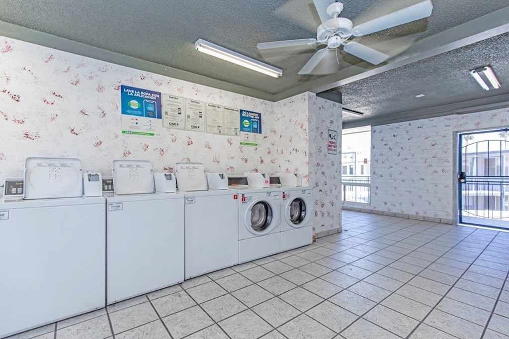 A laundromat with washers and dryers and a sign that says "No Trespassing.".