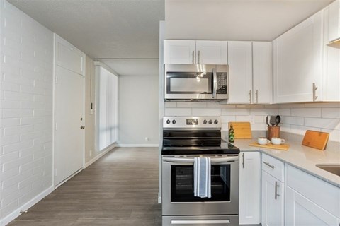 A kitchen with a stove top oven and a microwave above it.