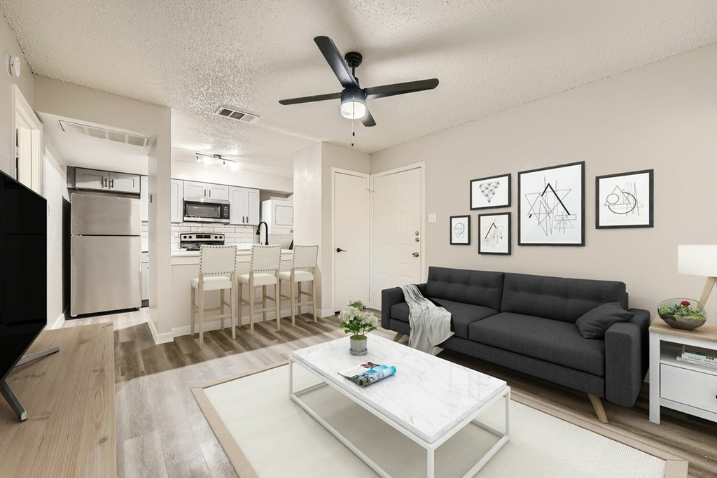 A living room with a grey couch and a white coffee table.