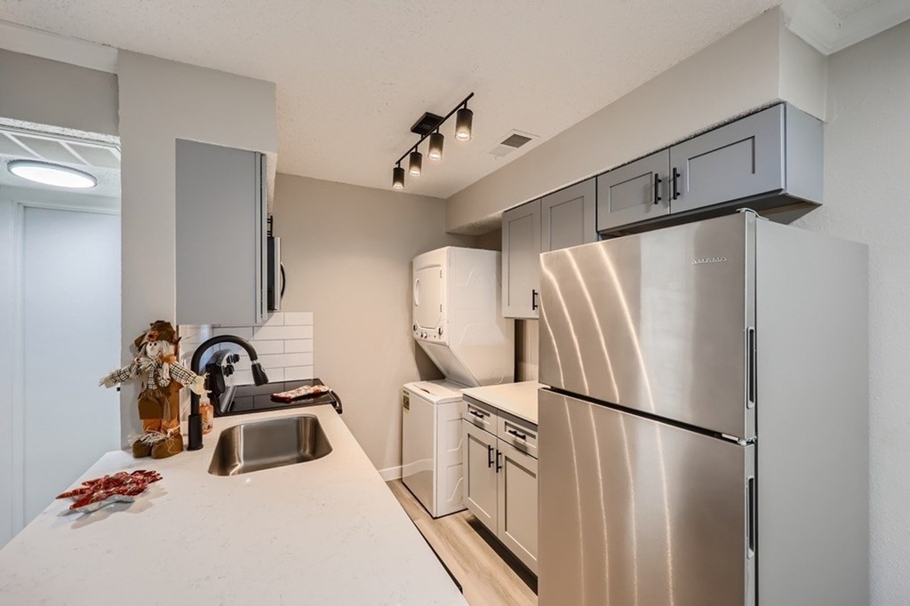 A modern kitchen with stainless steel appliances and a white countertop.