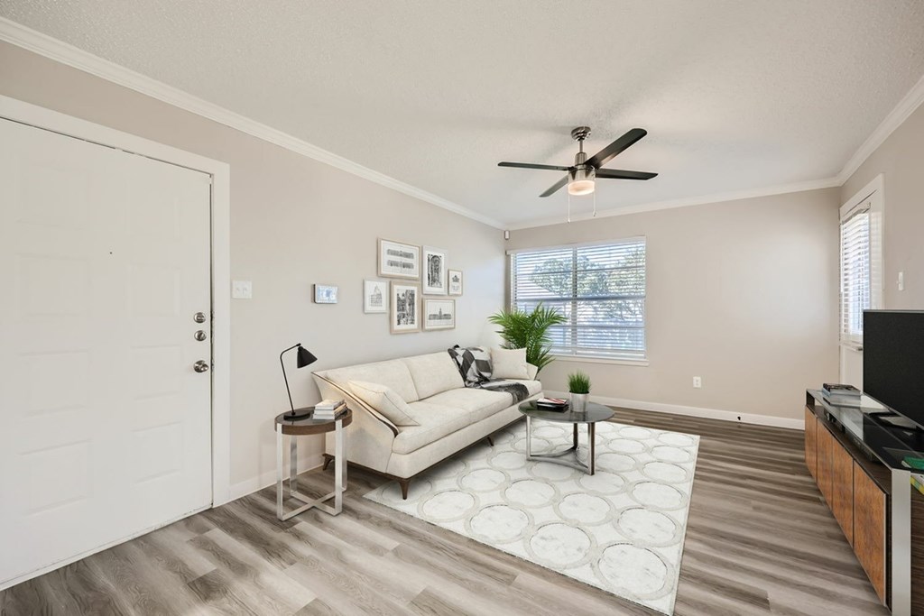 A living room with a white couch and a ceiling fan.