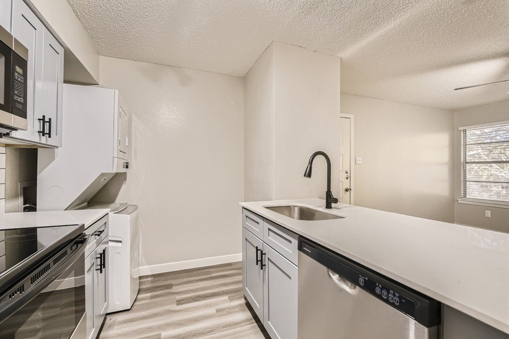A kitchen with white cabinets and stainless steel appliances.