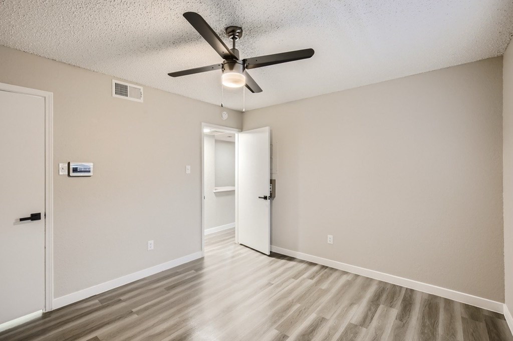 A room with a ceiling fan and two doors.