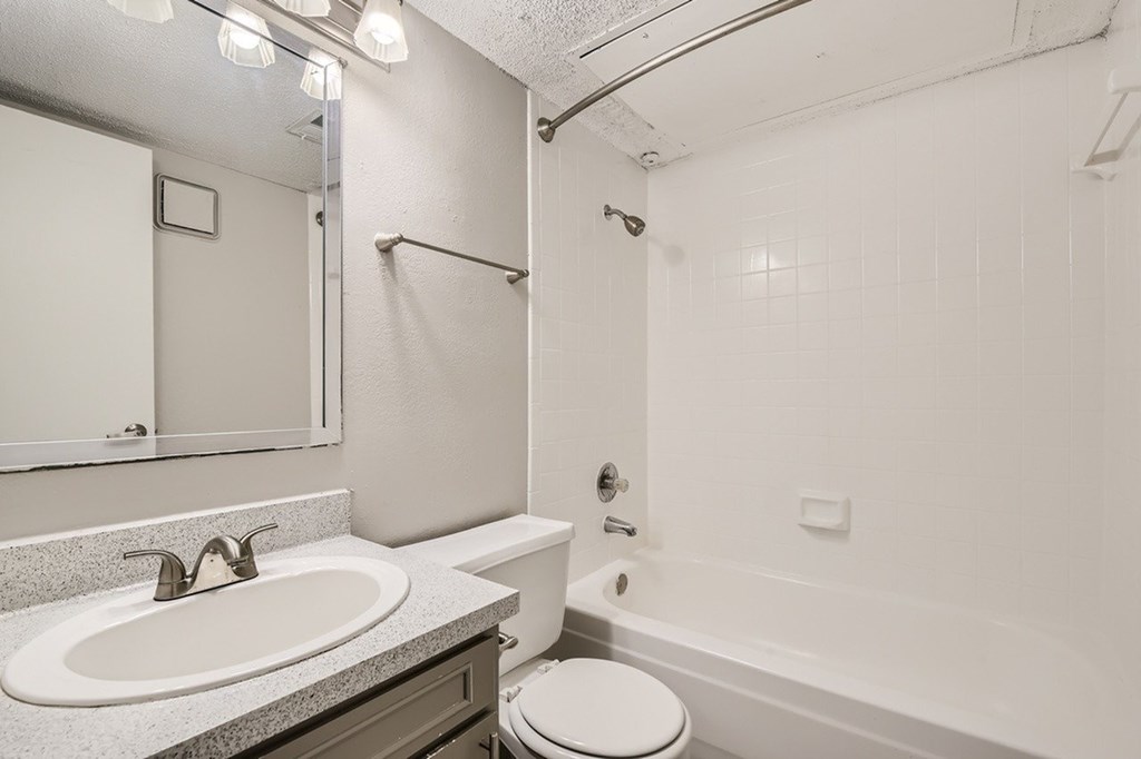 A white bathroom with a sink, toilet, and bathtub.