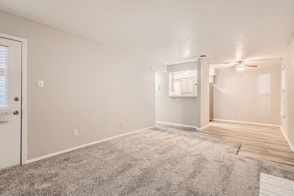 A room with a carpeted floor and a ceiling fan.
