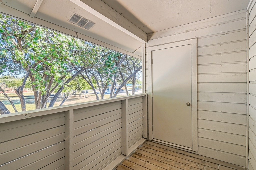 A white door is on the right side of a room with wood paneling.