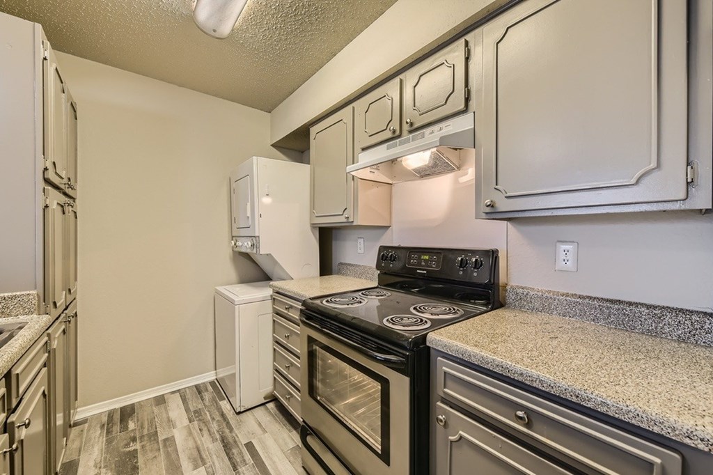 A kitchen with a stove top oven and a refrigerator.