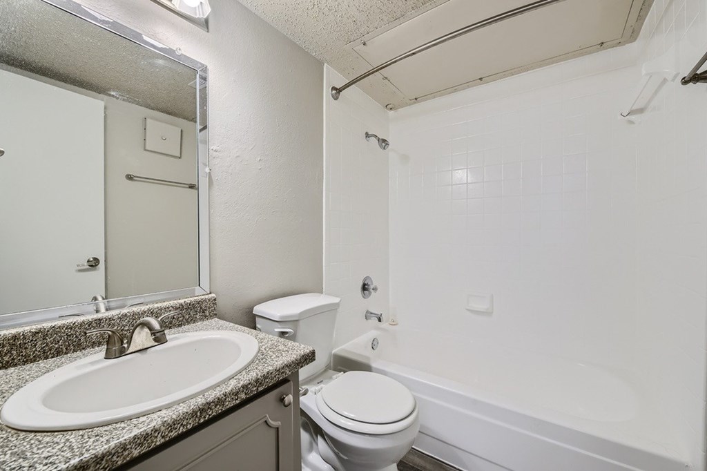 A bathroom with a sink, toilet, and bathtub.