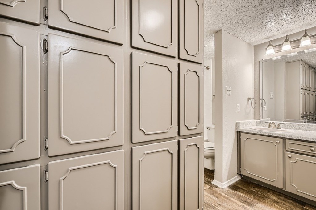 A bathroom with a vanity, sink, and mirror.