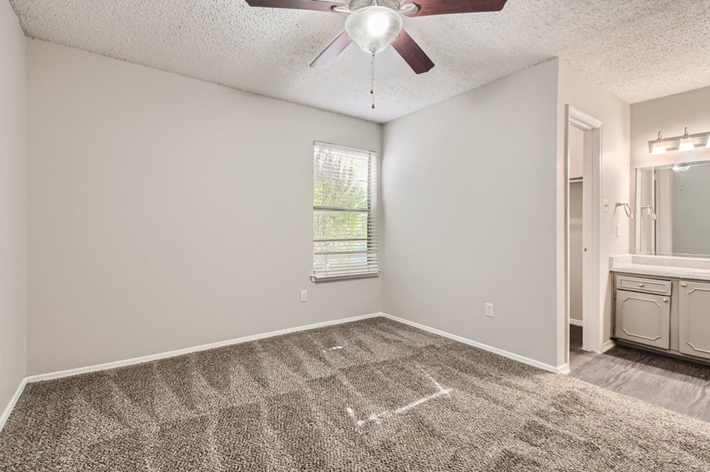 A room with a ceiling fan and a carpeted floor.