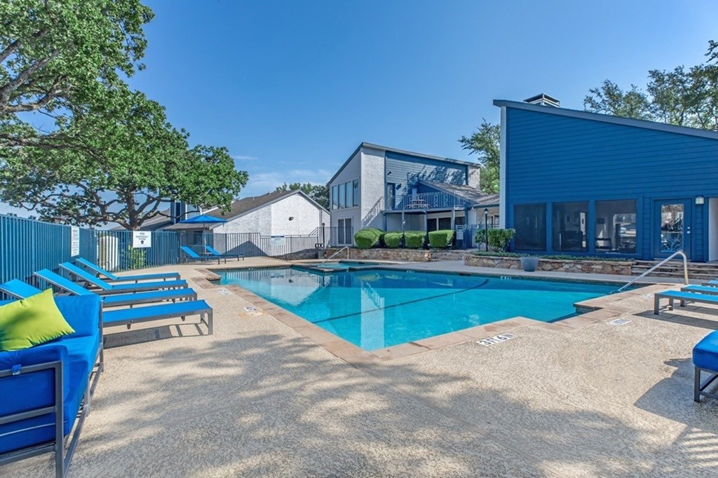 A blue pool surrounded by a blue lounger and a blue building.