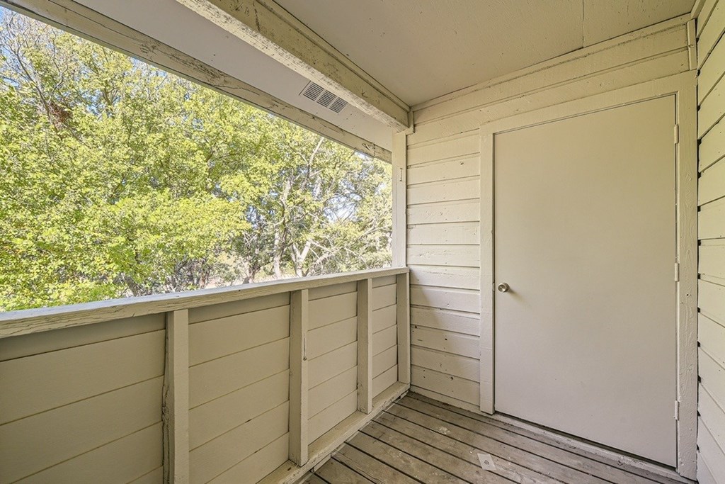 A white door is on the right side of a porch.