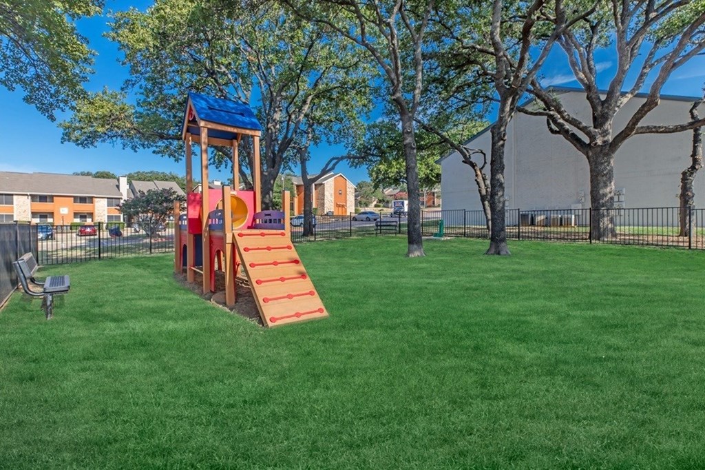 A playground with a red slide and a blue roof.