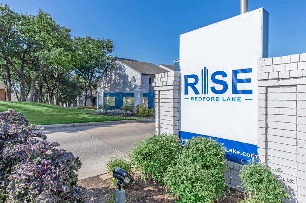 A sign for RISE Bedford Lake stands in front of a building.