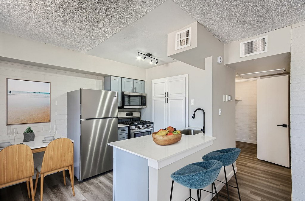 A modern kitchen with a refrigerator, stove, and sink.