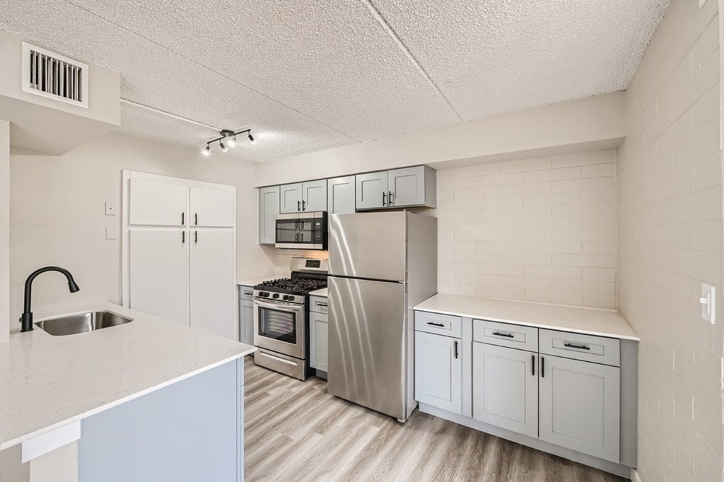 A kitchen with white cabinets and appliances.