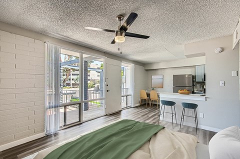 A living room with a green couch and a ceiling fan.