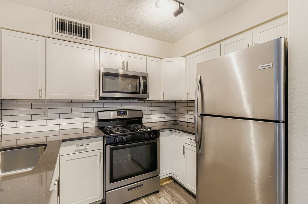 A kitchen with a black countertop and stove.