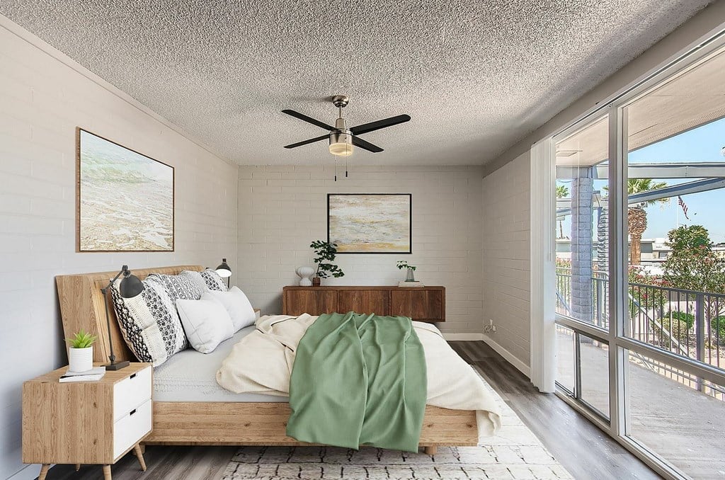 A bedroom with a bed, nightstand, and a ceiling fan.