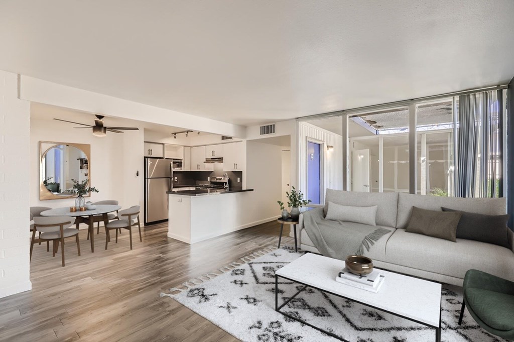 A modern living room with a kitchen in the background.