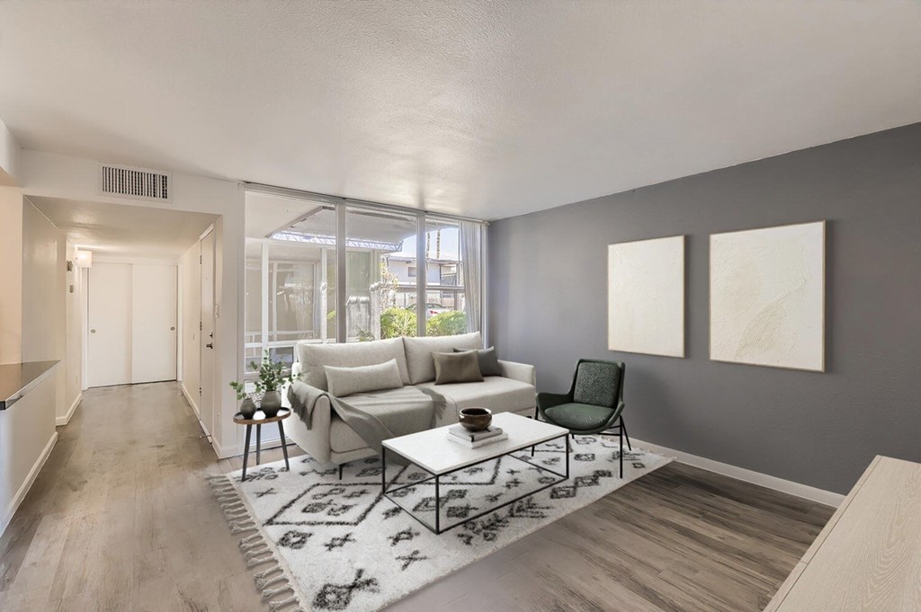A living room with a grey wall and a white couch.
