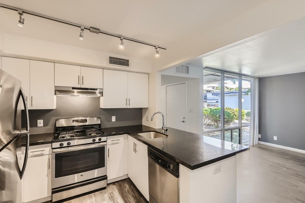 A modern kitchen with white cabinets and stainless steel appliances.