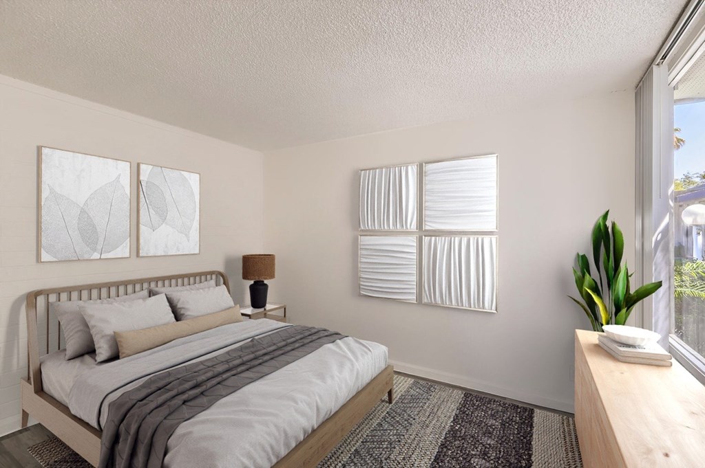 A bedroom with a bed, nightstand, and window with blinds.