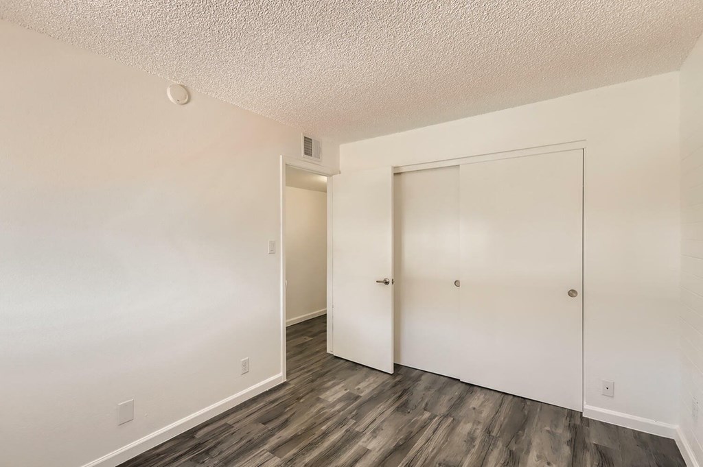 A room with a white door and a grey floor.