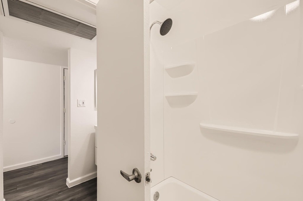 A white door with a black handle and a black circular object on the wall.