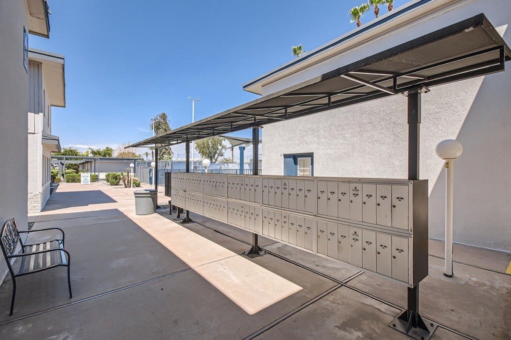 A row of mailboxes are lined up on a sidewalk.
