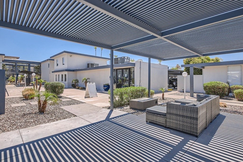 A modern outdoor seating area with a white building in the background.