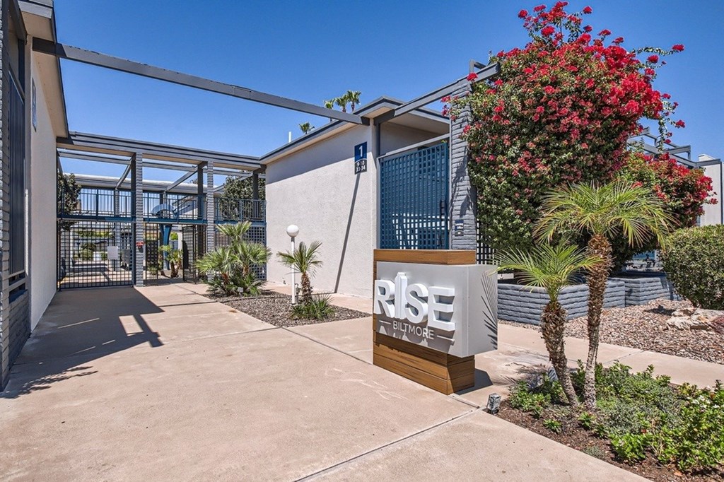 A sign that says "RISE" is in front of a building.