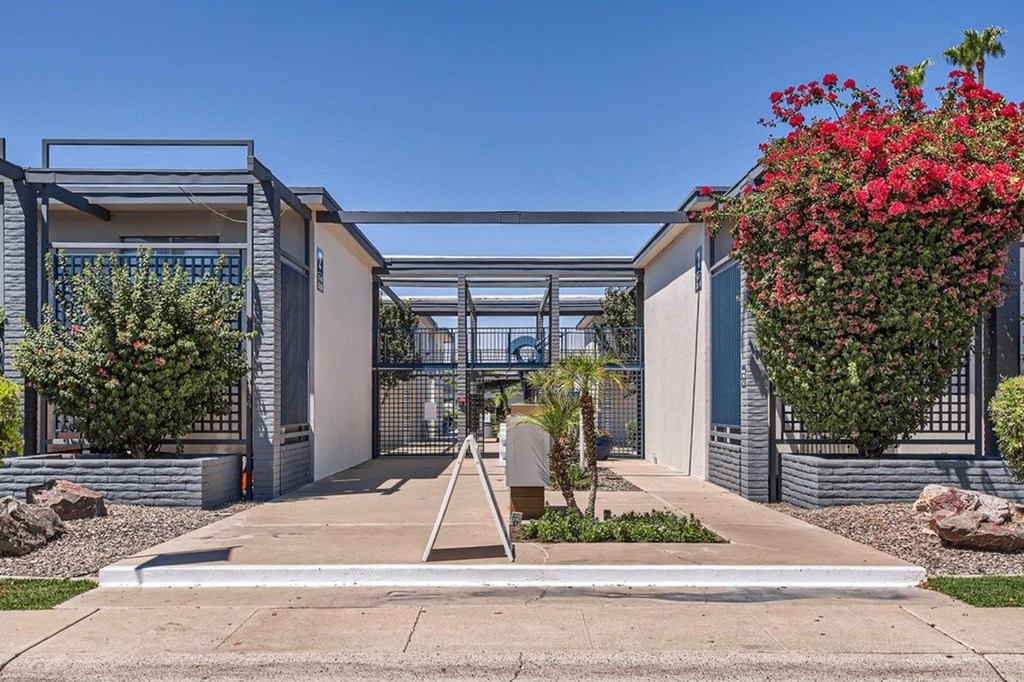 A modern house with a white fence and a small garden in front.