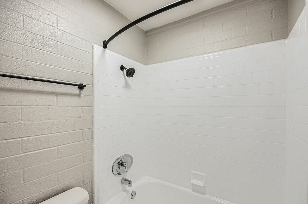 A white bathroom with a toilet and a shower.