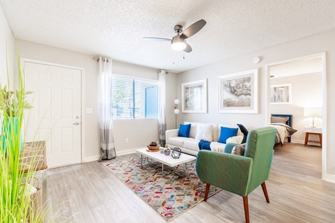 A living room with a green chair and a white couch.