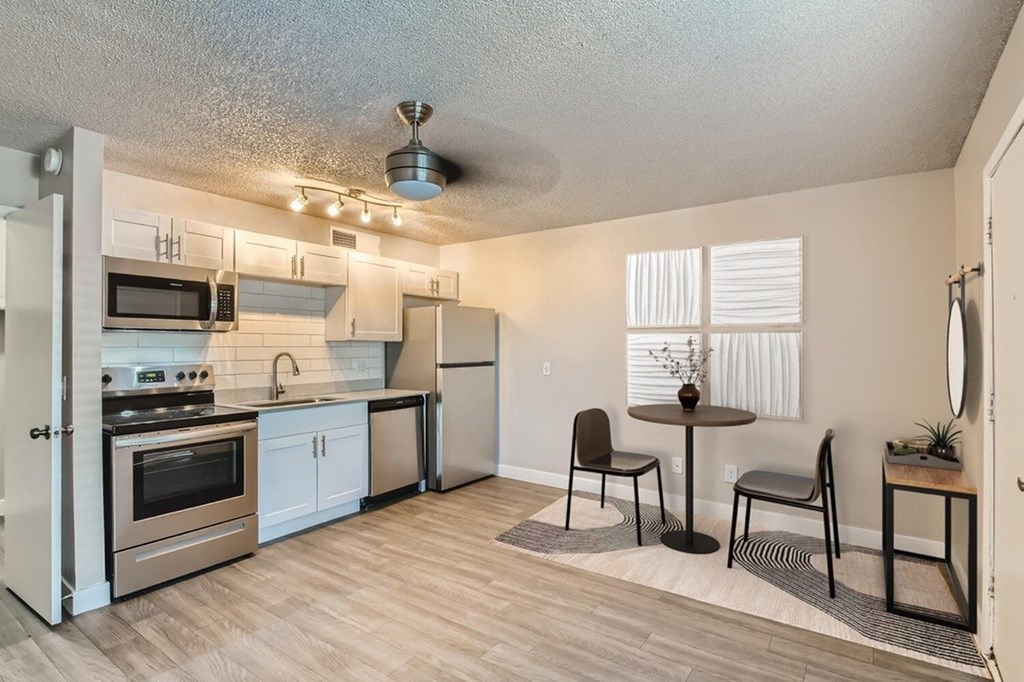 A kitchen with a refrigerator, oven, and microwave.