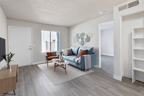 A living room with a blue couch and a wooden coffee table.