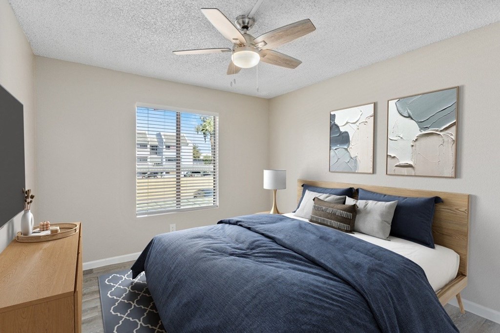 A bedroom with a bed, nightstand, and two wall art pieces.