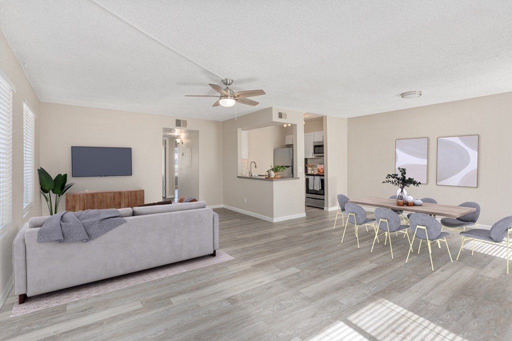 A modern living room with a grey sofa and a dining table set up.