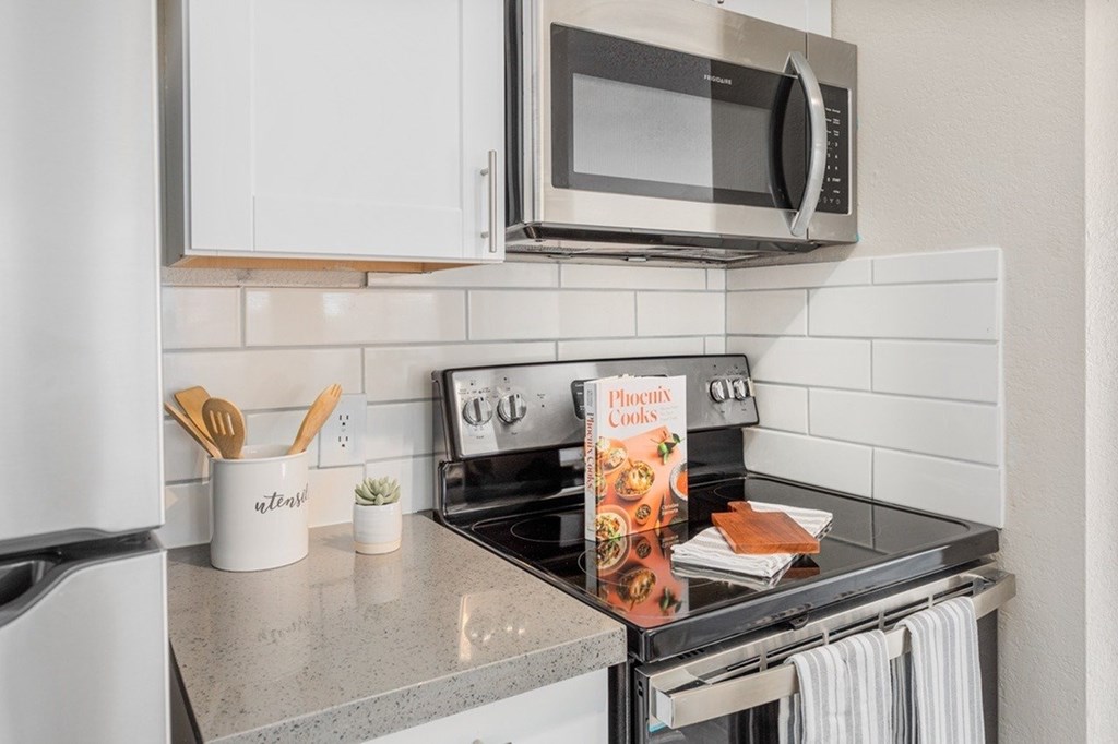 A kitchen with a stove top oven and a microwave above it.