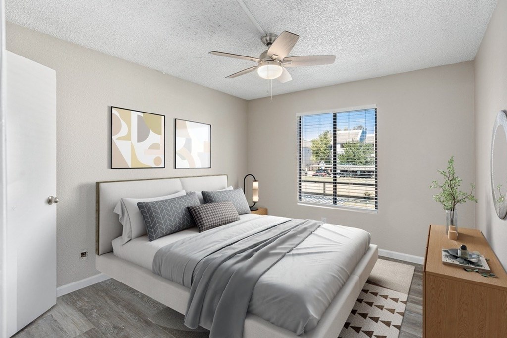 A bedroom with a large bed and a ceiling fan.