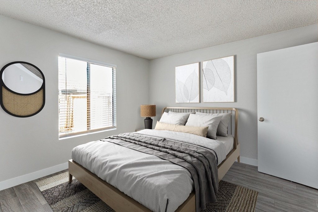 A bedroom with a large bed and a round mirror on the wall.