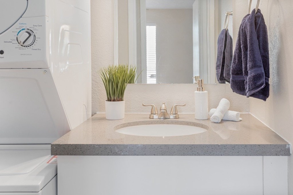 A bathroom with a white toilet, a sink, and a mirror.