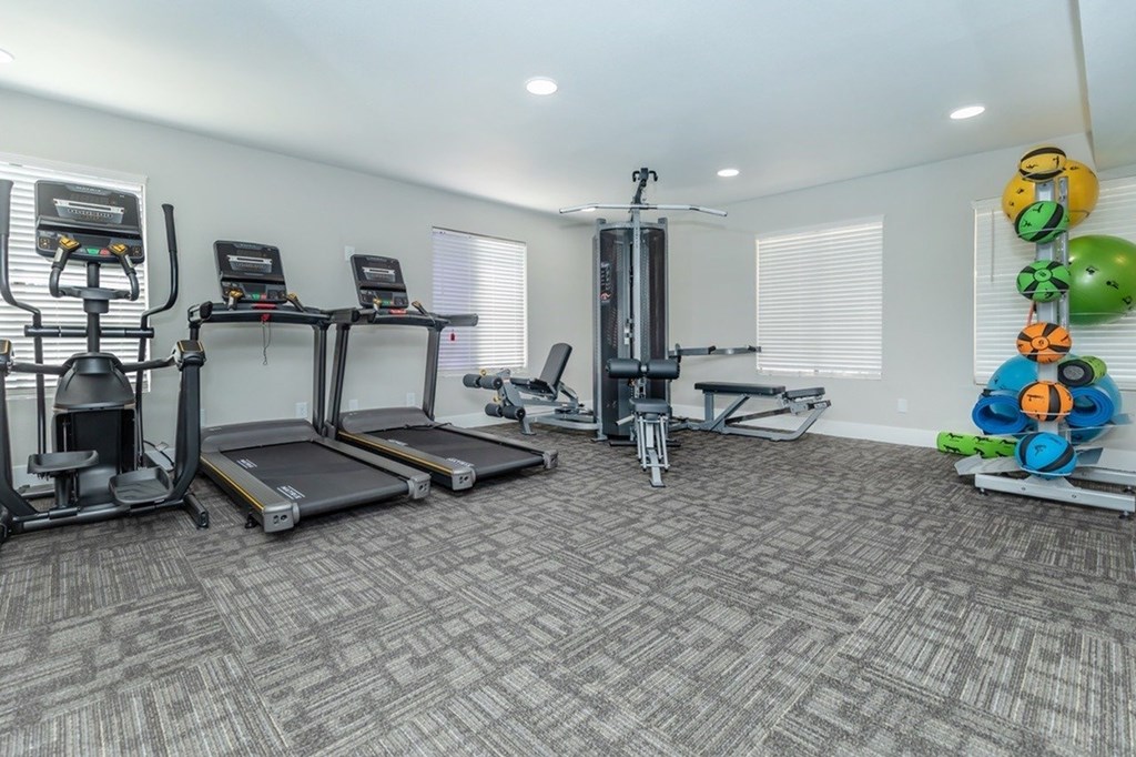 A well-equipped gym with treadmills, exercise bikes, and weight machines.