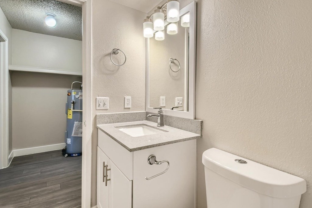 A bathroom with a white sink and a white toilet.
