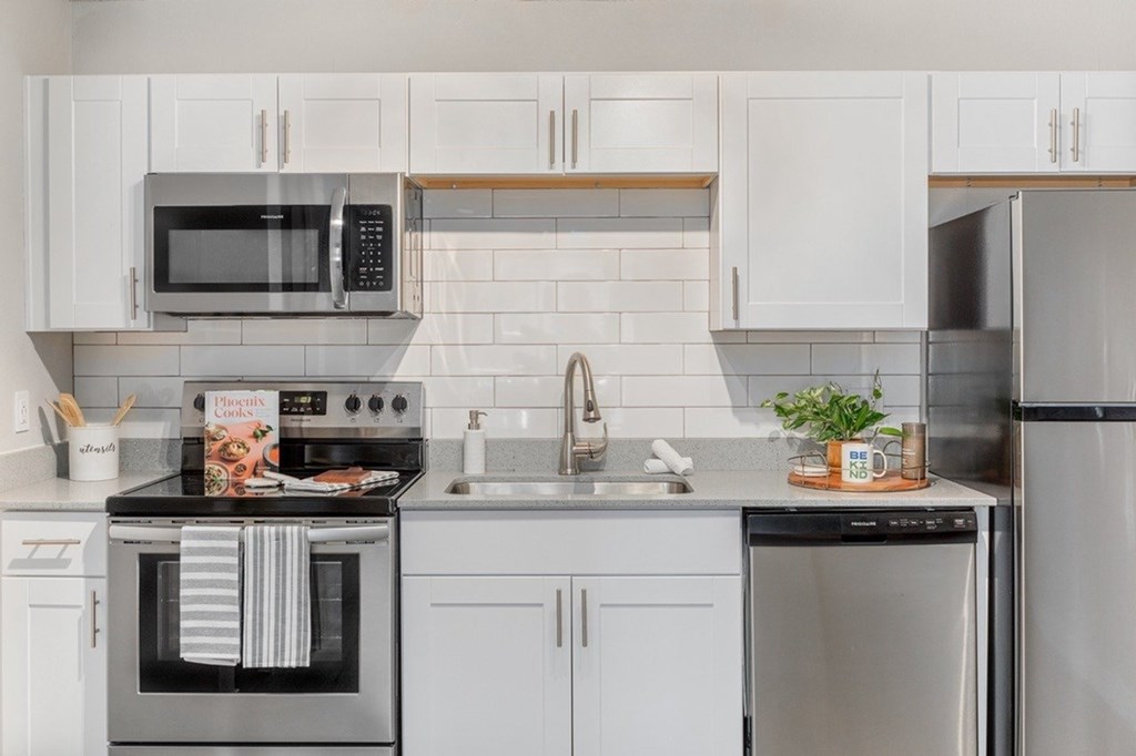 A modern kitchen with a stove, microwave, and refrigerator.