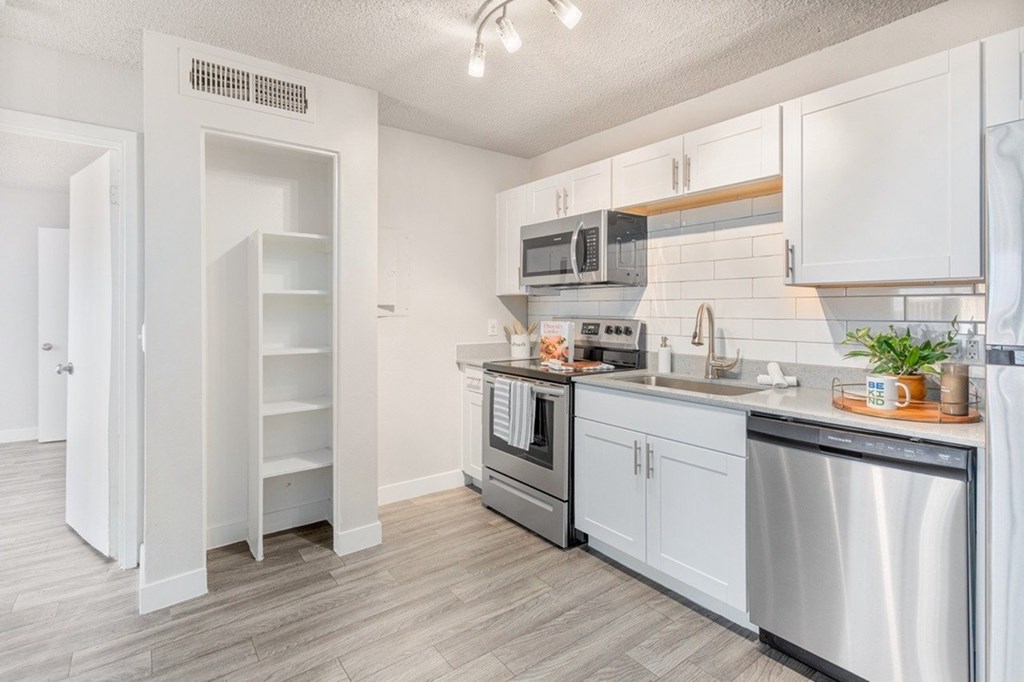 A kitchen with white cabinets and stainless steel appliances.